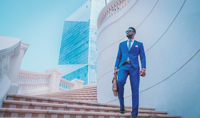 doctorpreneur wearing suit and holding briefcase, standing outside on steps