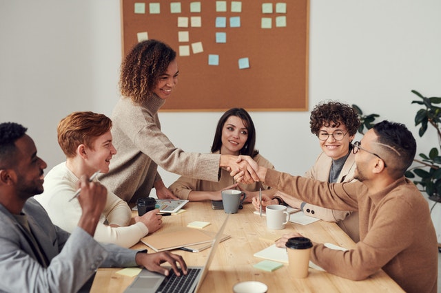 employees sitting at table smiling