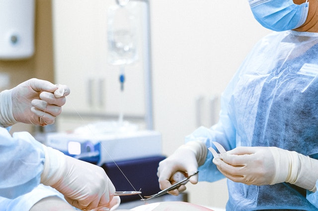 surgeons stitching up patient