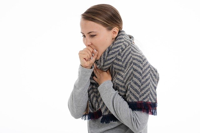 woman wearing blanket coughing