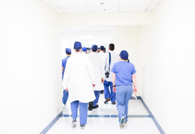 A back view of a group of doctors walking in the hospital