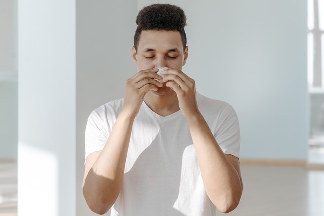 A man wiping his nose with a tissue