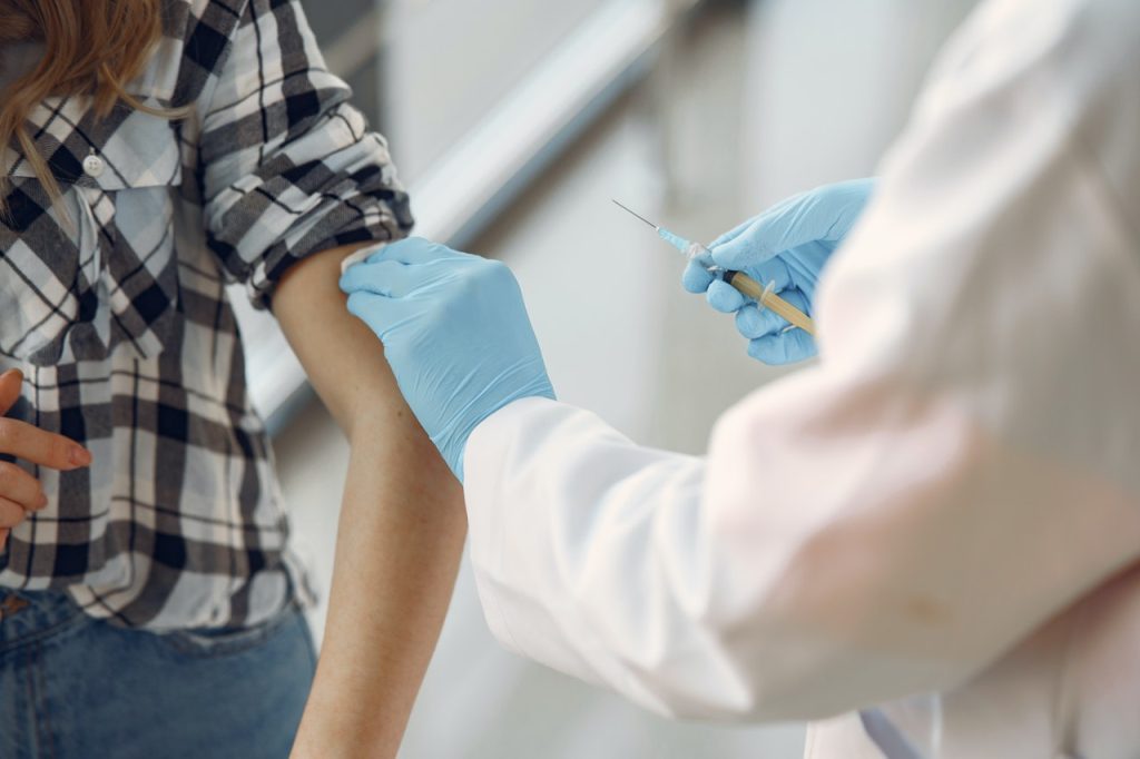 doctor giving COVID-19 vaccine to patient