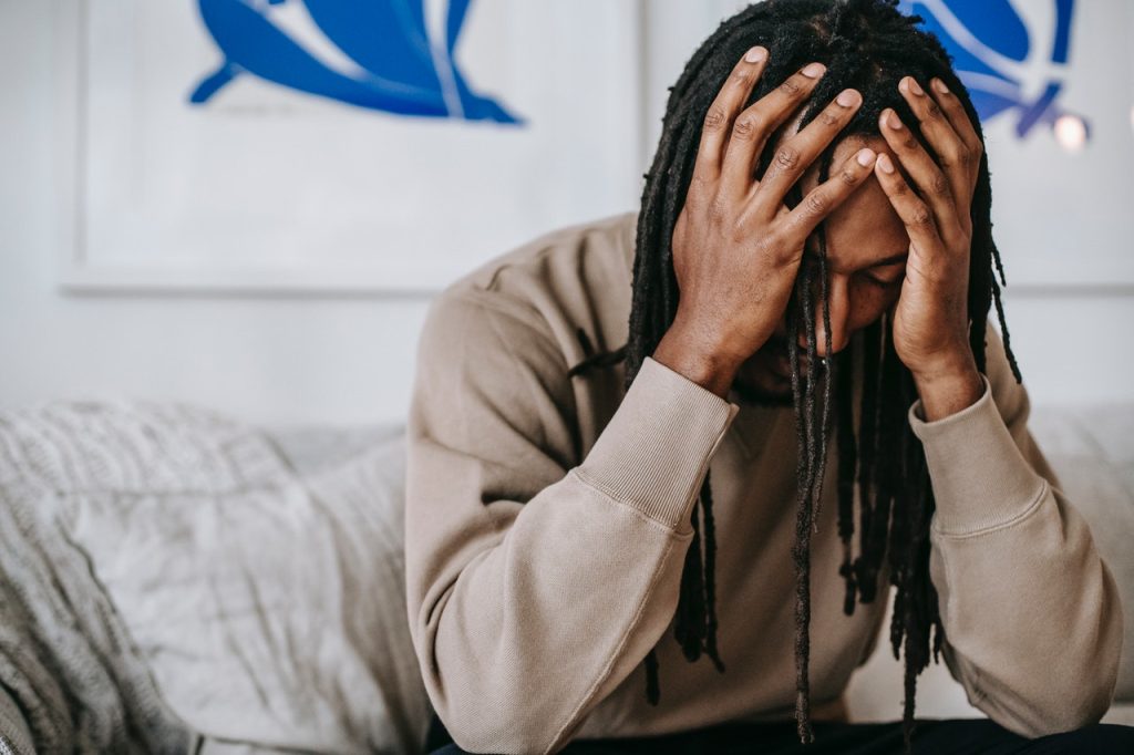 man with headache putting head in hands