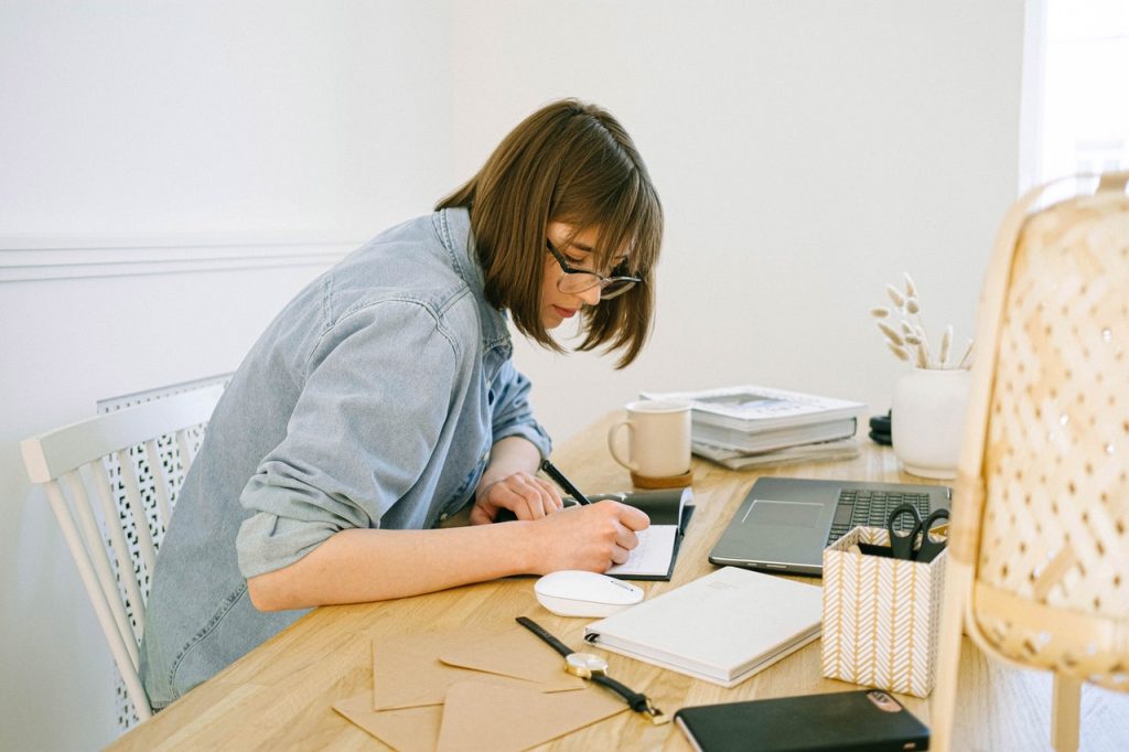 woman taking notes at desk