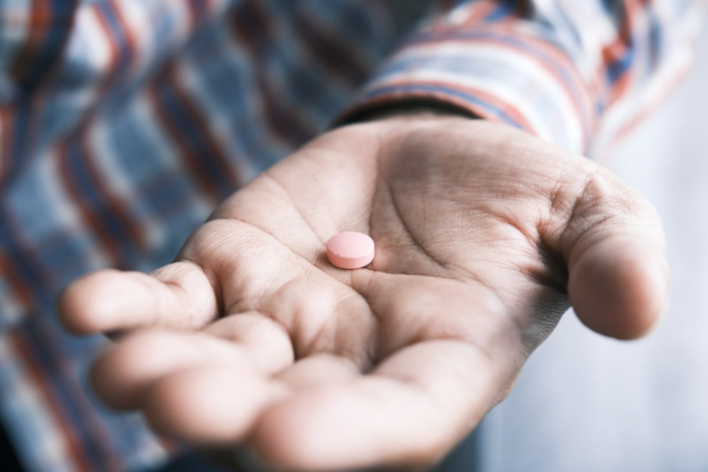 A person holding anti-allergy medication in their hand