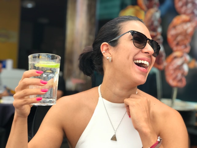 Woman holding a glass of water, laughing