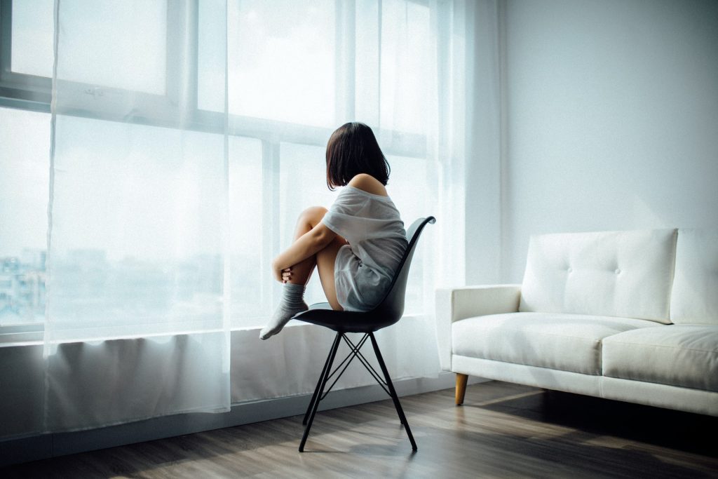 A woman sitting and staring outside a window