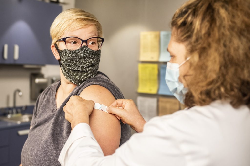 woman receiving vaccine from doctor