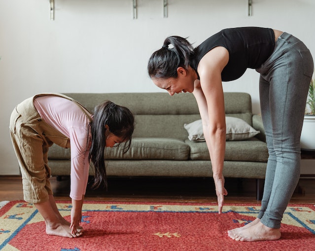 mom and daughter stretching to improve heart health