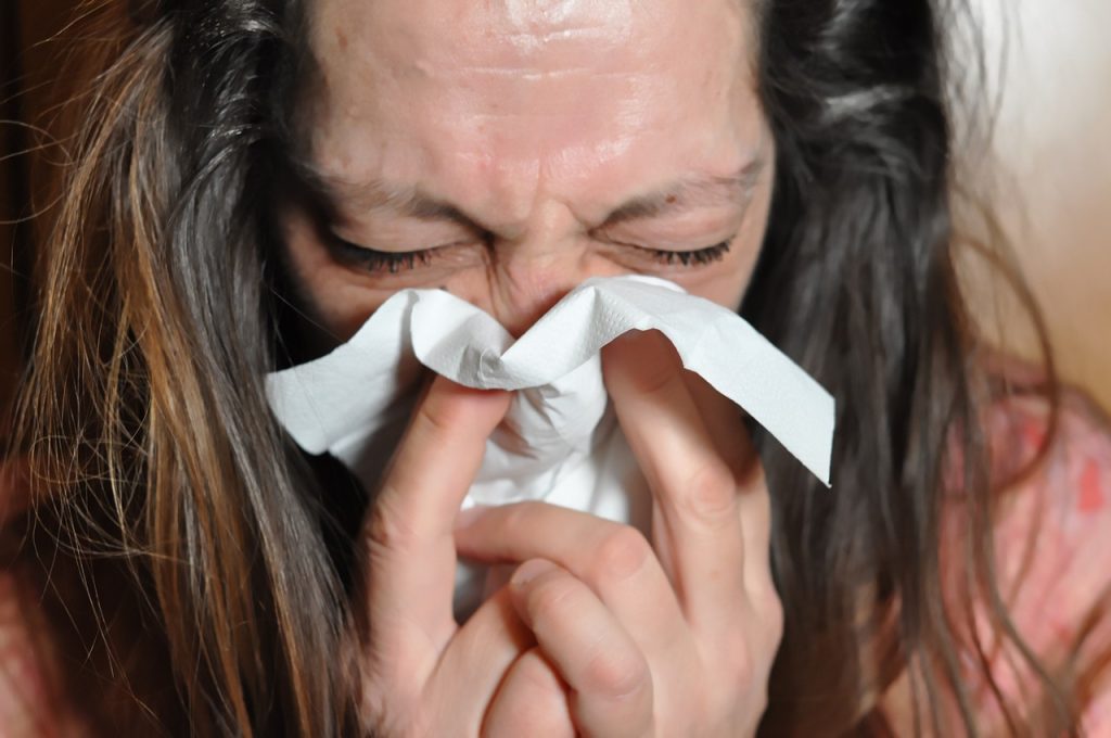woman sneezing with common cold