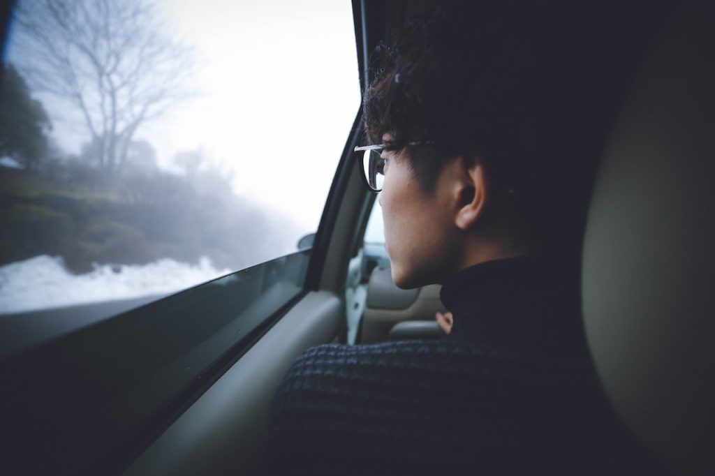 man with seasonal affective disorder looking out car window