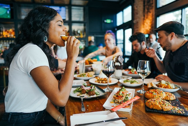 woman eating at a table in a restaurant with friends