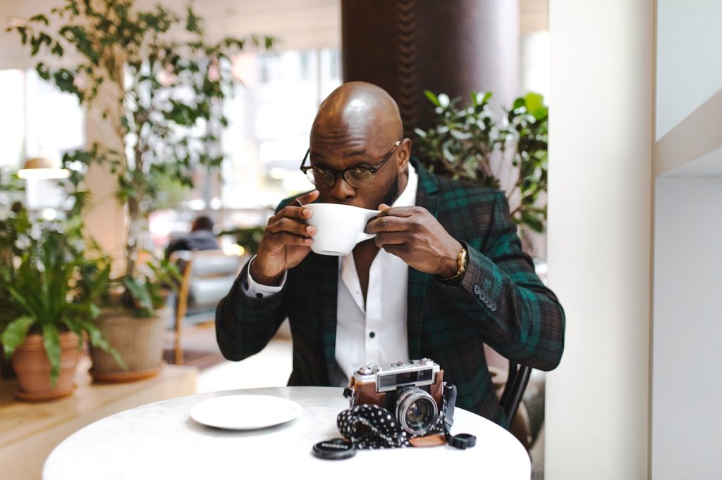 man drinking coffee while traveling