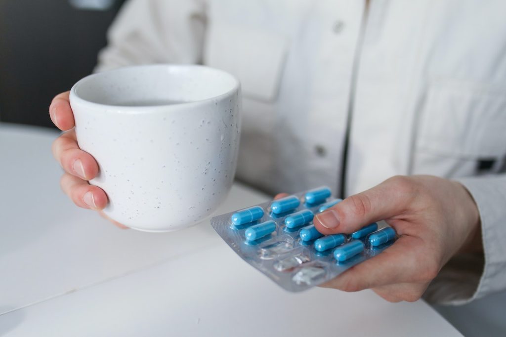 person holding blue pills