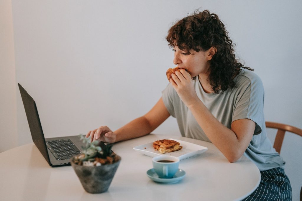 female employee eating pastries at her desk