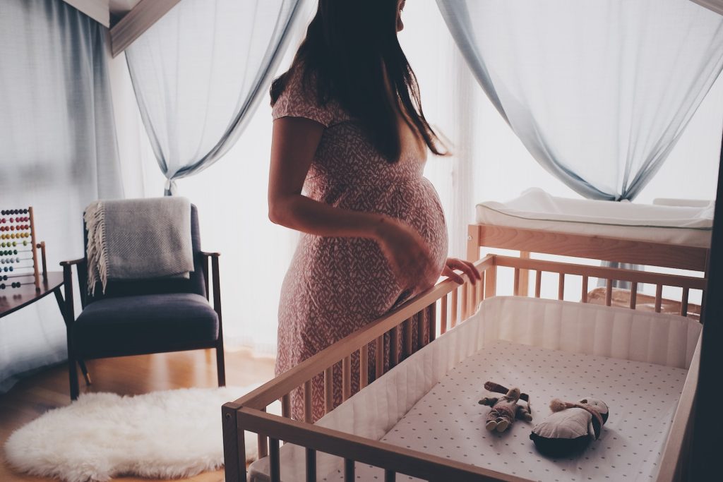 Pregnant woman standing in her nursery