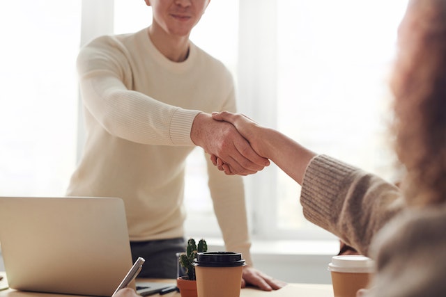 two people shaking hands after negotiating