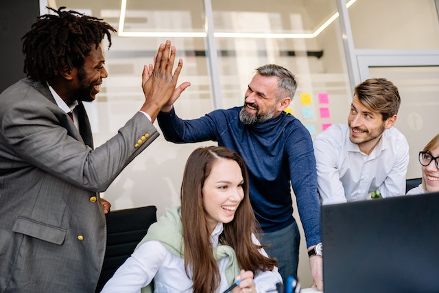 employees smiling and giving a high-five