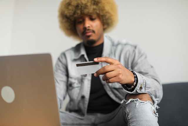 A man shopping on his laptop with a credit card