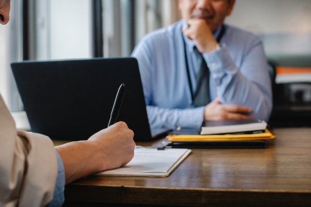 Sales rep taking notes in a client meeting