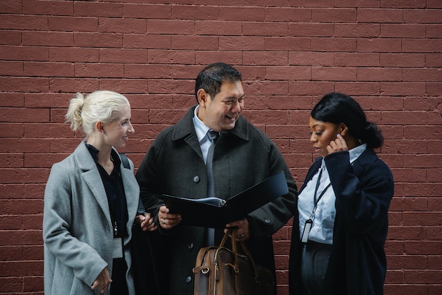 Three people talking outside