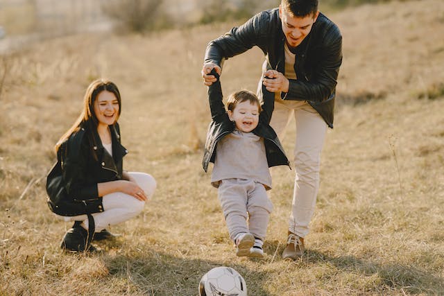 dad playing soccer with his kids