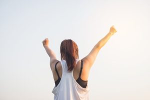 woman raising her arms in success