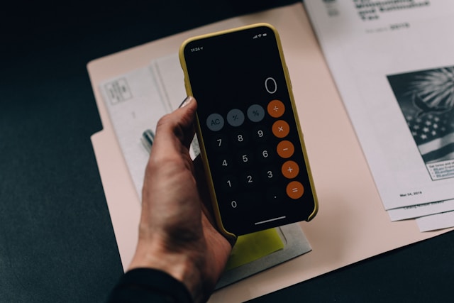 Person calculating startup costs with a calculator